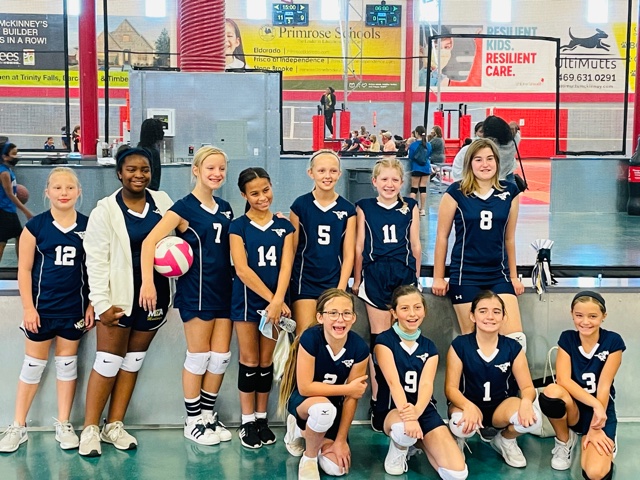 The fifth grade volleyball team stops for a team picture after their game. 
