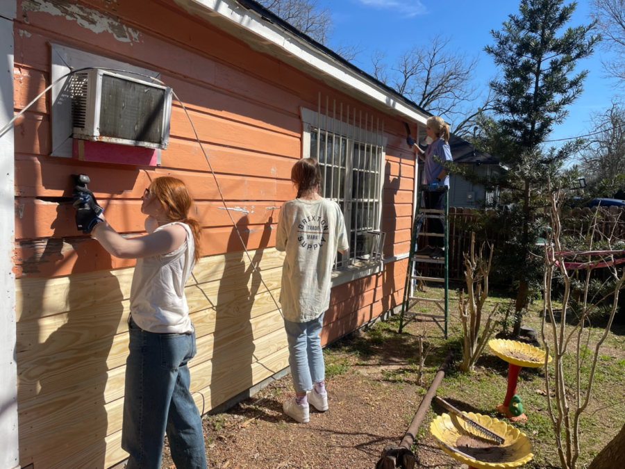 Sophomores Reagan Pogue and Grace Krause paint the outside of the house.
