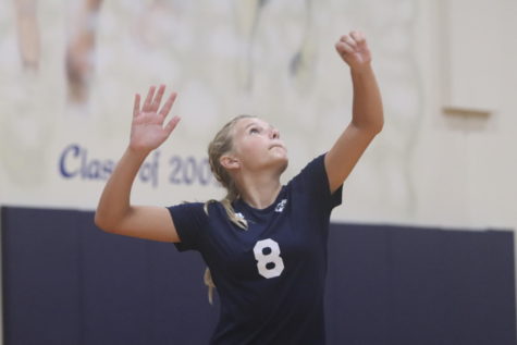 Molly Walsh, seventh, tosses the ball and prepares her serve.