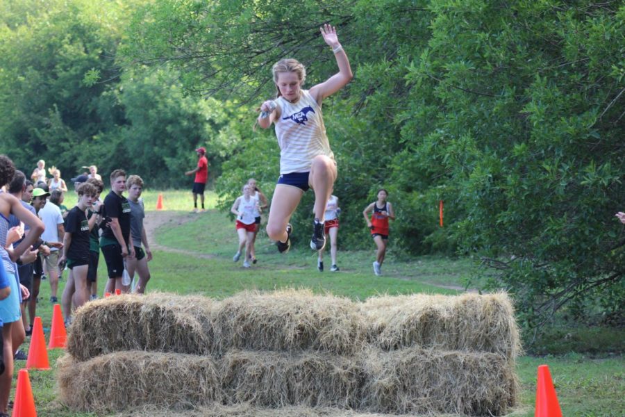 Leigh Evan Kitzmiller jumping over hay bale during the race.