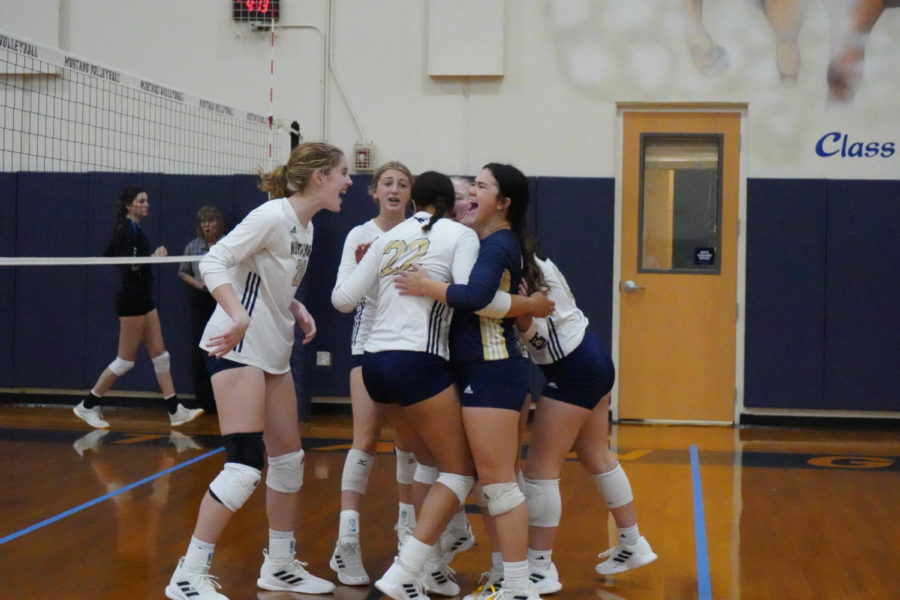 The Lady Mustangs celebrate after winning a match in the tournament.