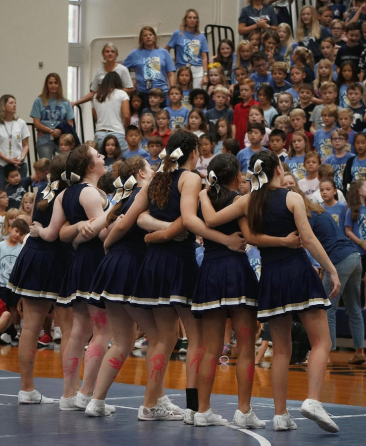 The Varsity cheerleaders and students finishing the pep rally with the fight song. 
