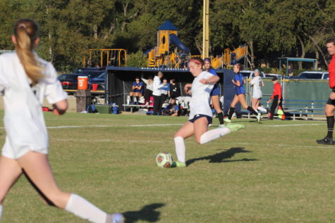 Junior Ava Thompson clears the ball out after winning it from the other team.