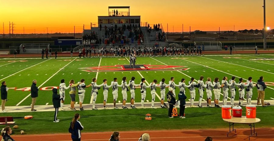 The football team stands for National Anthem.