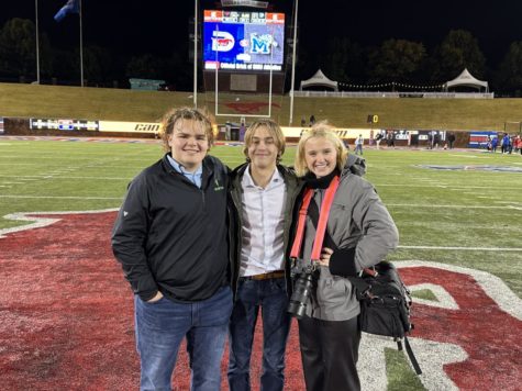 Three MCA broadcast students stand on the 50 yard line for a picture after the game.