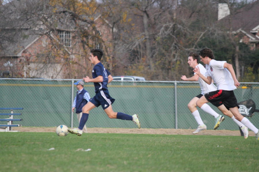 Junior, Micah Faulkner dribbles the ball down the field.