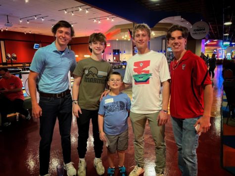 The varsity baseball players pose with Alex after some bowling.
