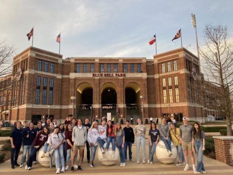 College tour students pose for a picture in front of Olsen Field.  