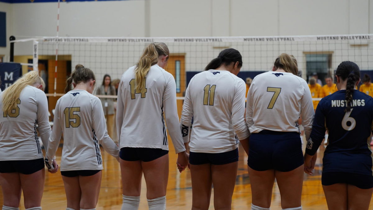 The MCA volleyball team lines up for prayer.