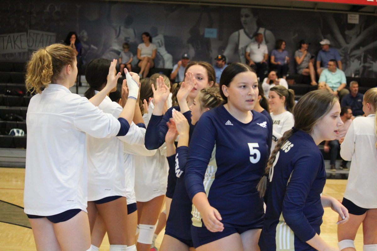 Varsity players high five the JV team after their 3 set win over Dallas Covenant. 