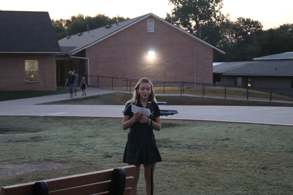 Eighth grader Presley Dreffs reads her prayer in front of the students and teachers. 