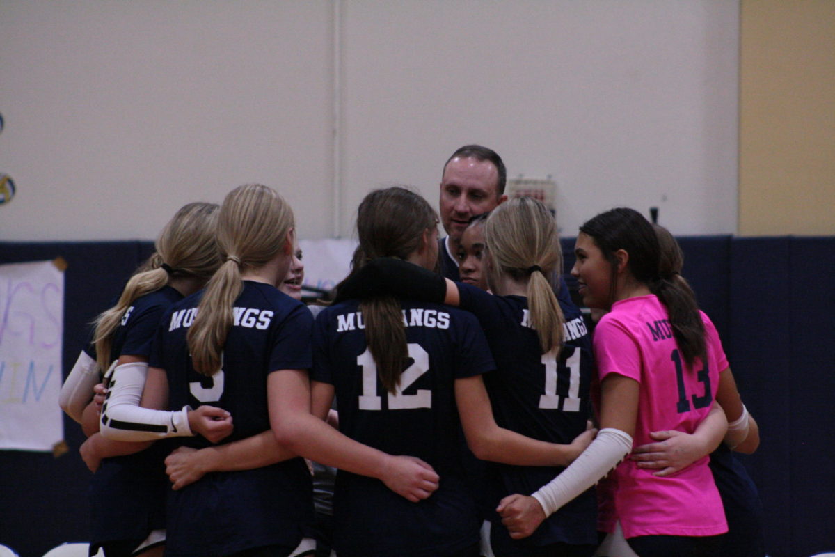 D1 Middle school volleyball team gathers together after the win.