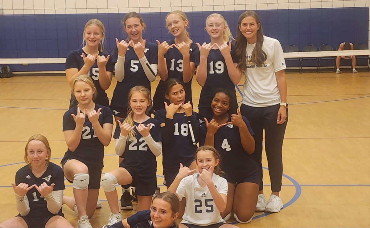 Middle School Volleyball pose for a picture after their tournament.