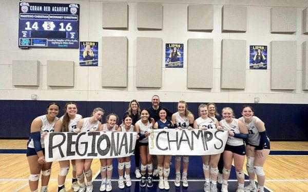 The girls pose with a regional champs sign after the win.