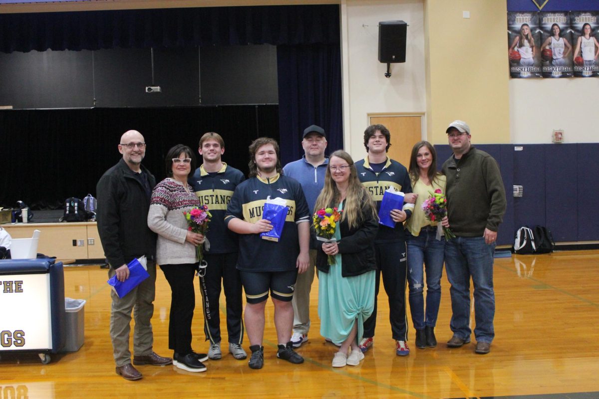 Senior wrestlers pose for a picture with their parents on Senior Night. 
