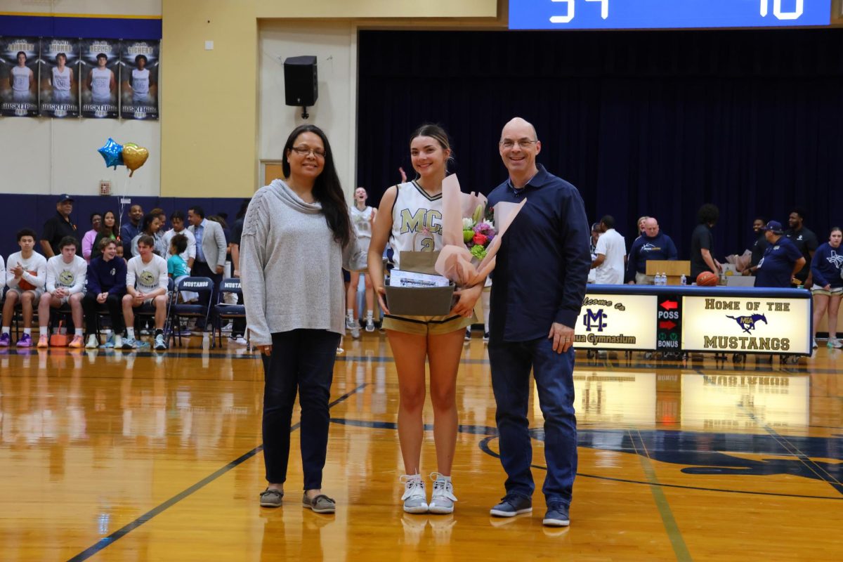 Senior Meilania Vance is escorted by her parents on Senior Night. 