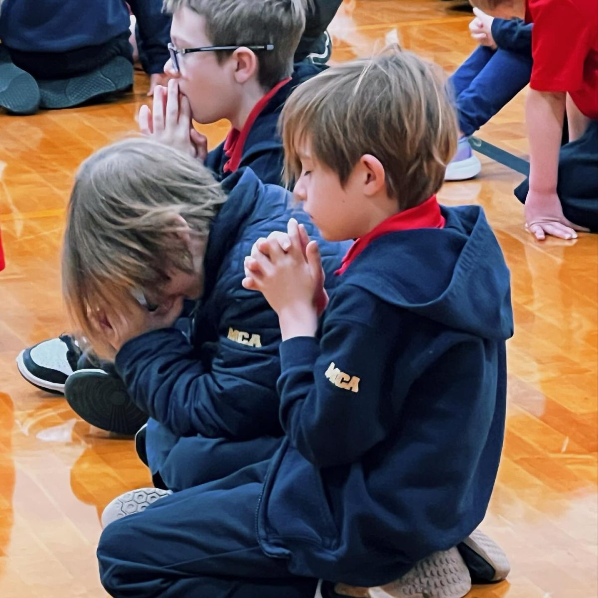 Kids in prayer during chapel.