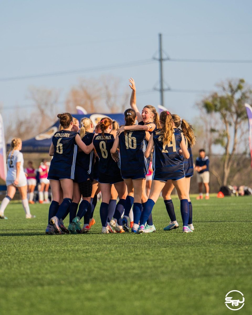 Varsity+womens+soccer+celebrates+after+scoring+in+the+state+championship+game.
