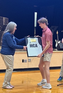 Senior David Roller receives his retired jersey from Athletic Director Judy Collins 