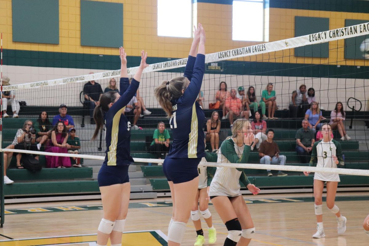 Freshman Tatum Carroll and sophomore Bailey Gerardis go up for the block. 