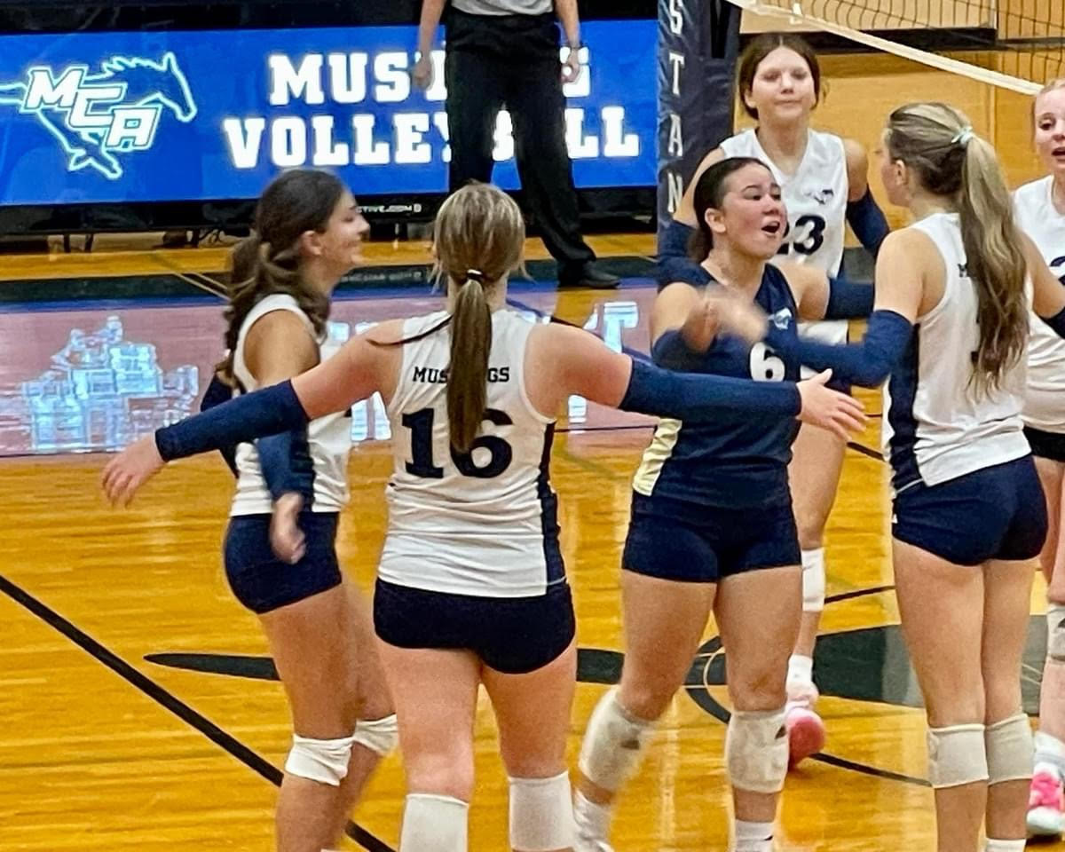 The Lady Mustangs celebrate with each other after receiving the point. 