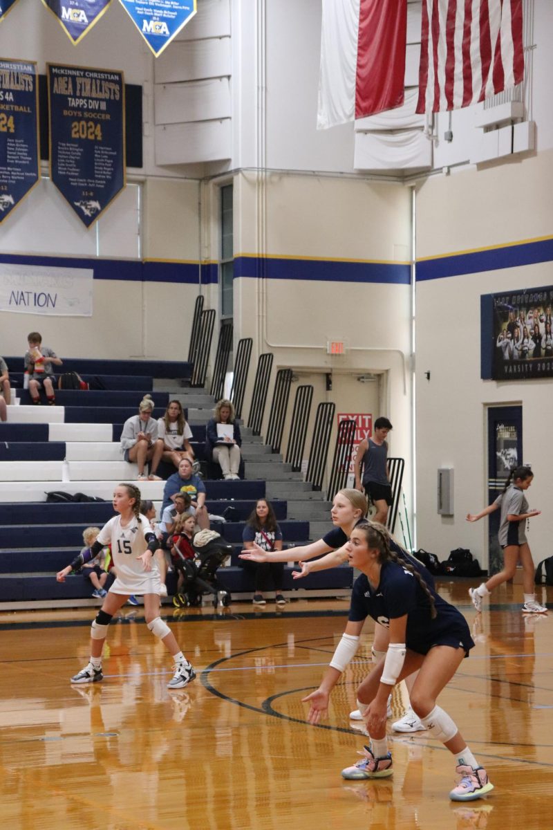 Eighth graders Kate Thomas, Sophia Mejan and Sara Radtke get ready for the serve.