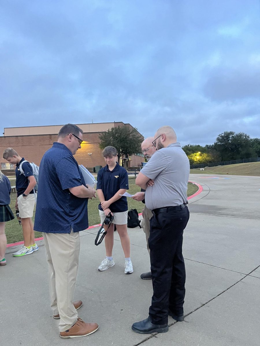 Sophmore Jude Bleecker gathers with staff memebers for prayer