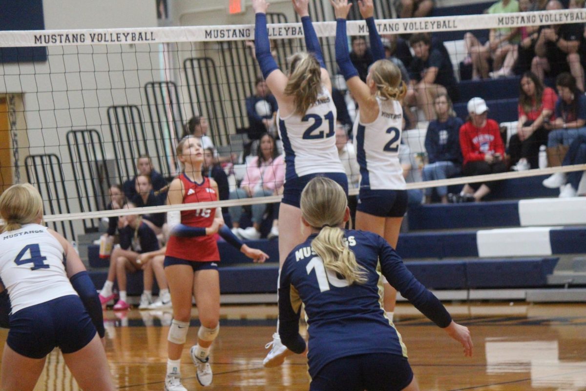 Freshmen, Tatum Carroll and Lyla Schmitz, jump for the block.