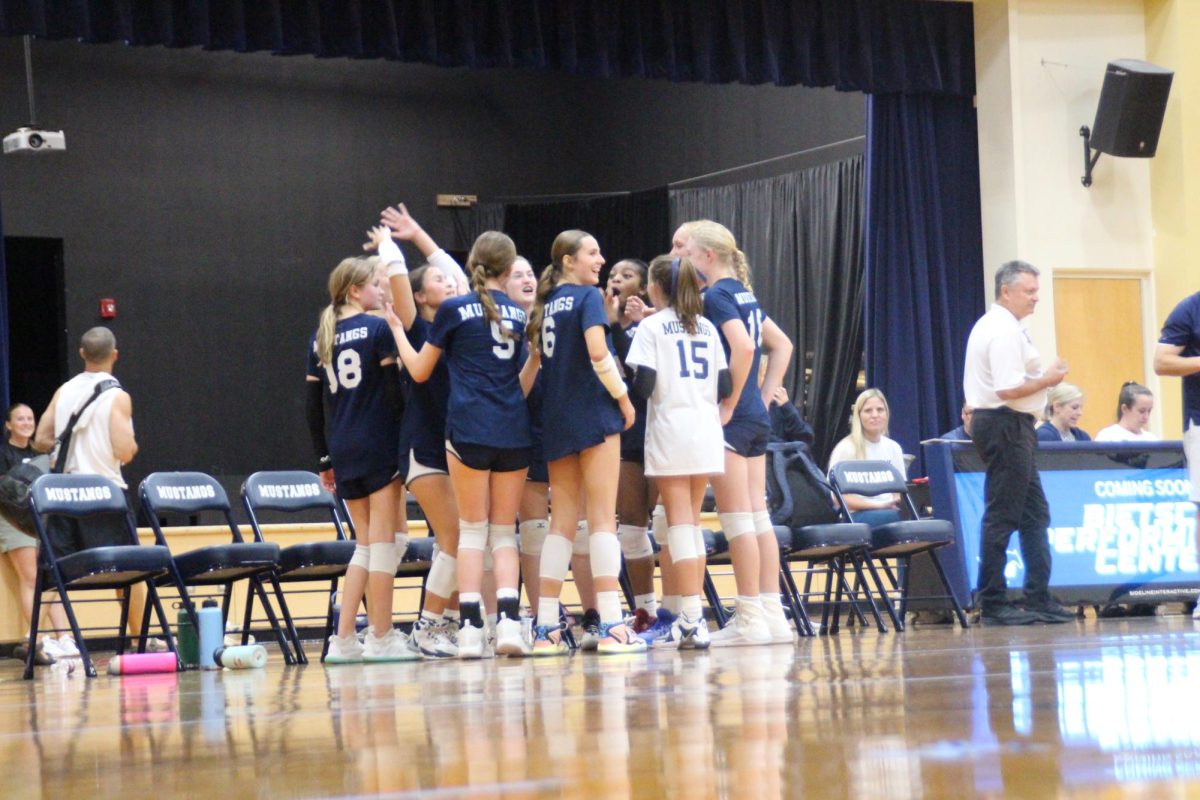 The volleyball team gets a pep-talk from their coach before the next set. 