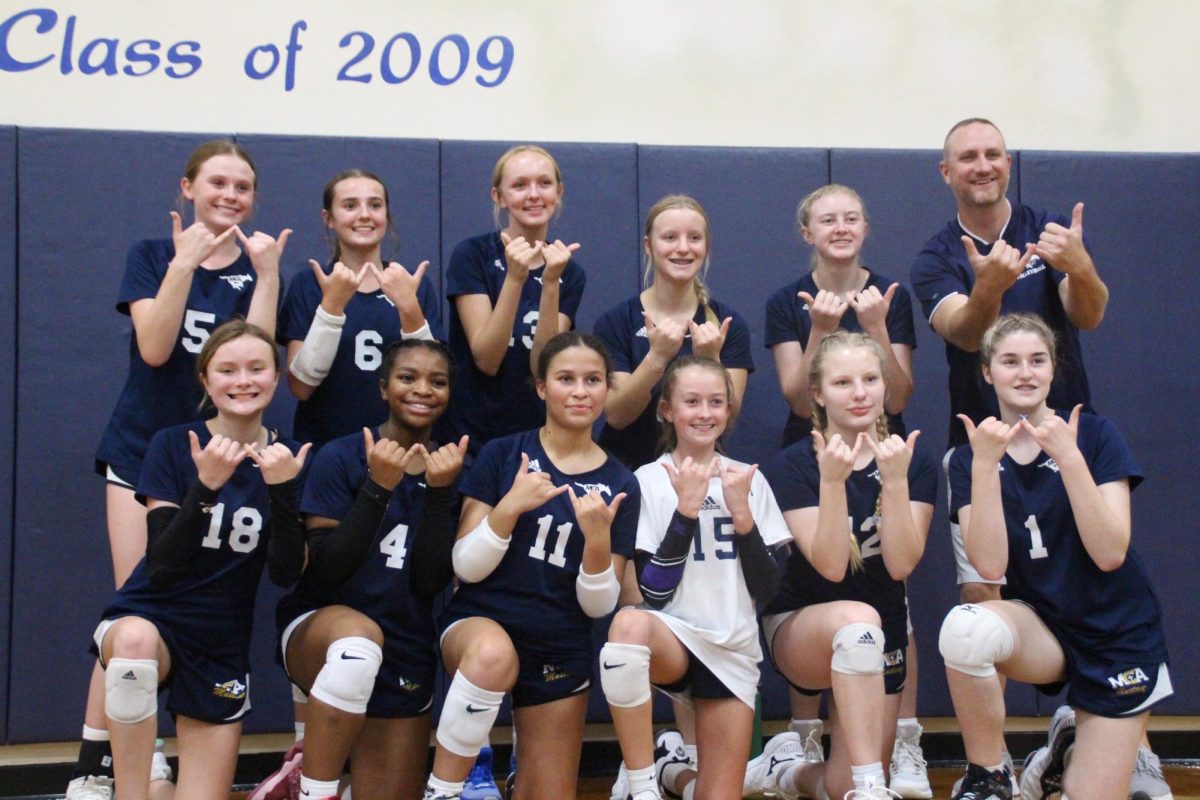 The D1 volleyball team poses for a picture after their win. 