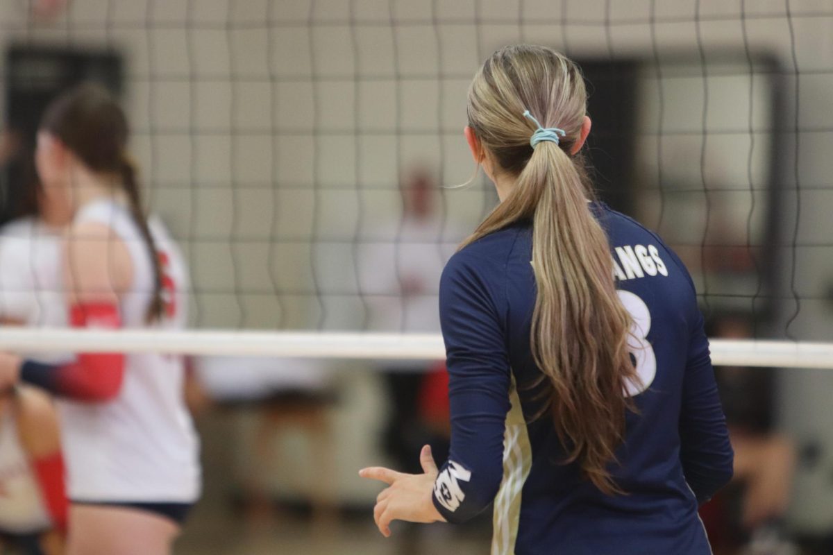 Senior Kadence Ackmann stands at the net.