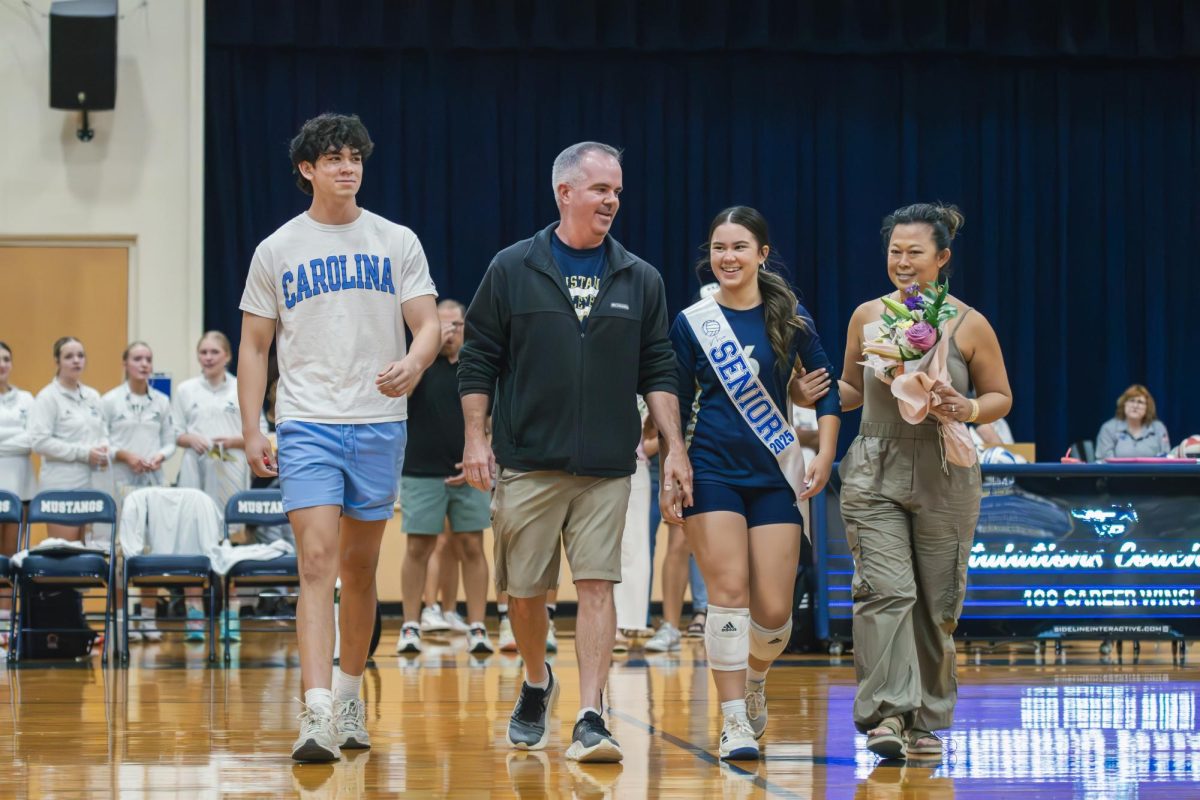 Senior Mia Gunn walks with her family for senior night