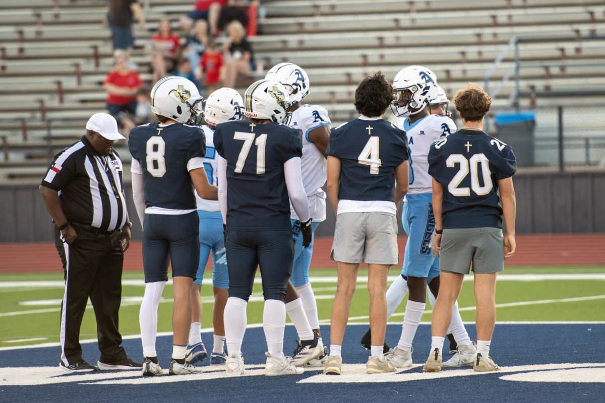 The captains of each football team meet for the coin toss. 