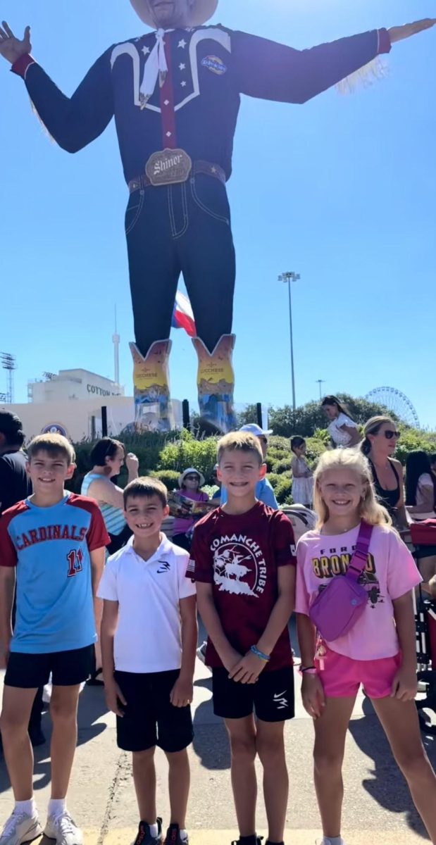 Kids take picture with big Tex.