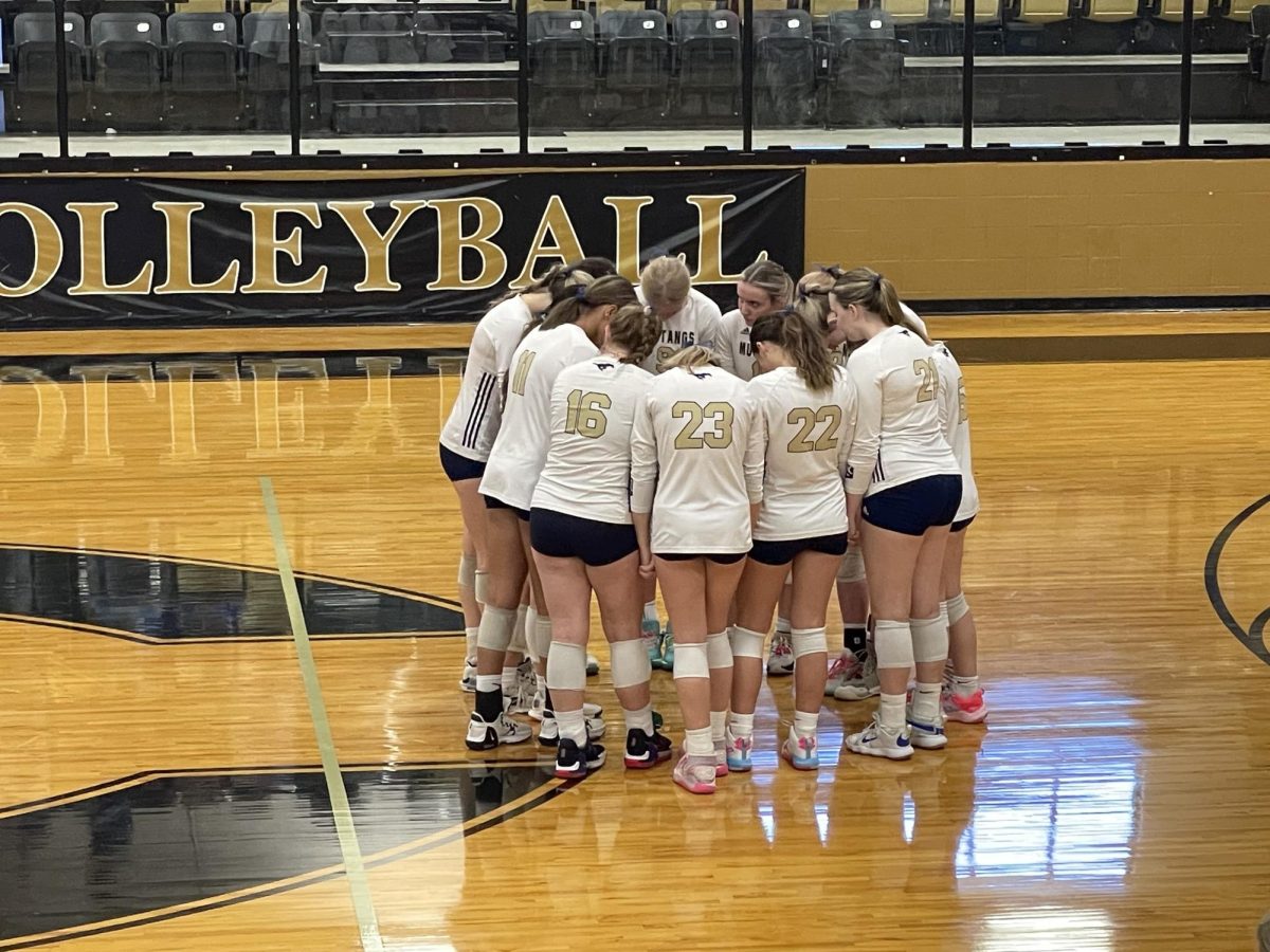 Lady Mustangs come together before the game to pray.