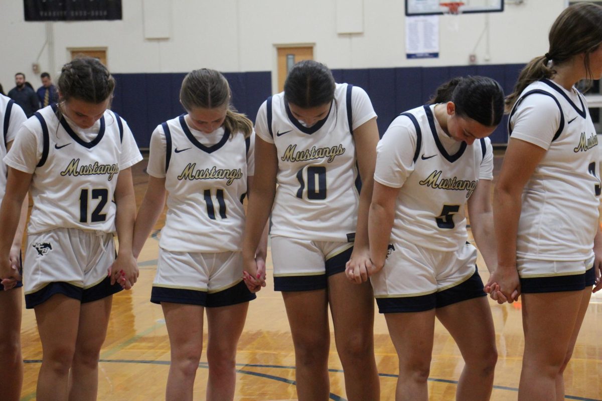 The team bows their heads to pray before the game.