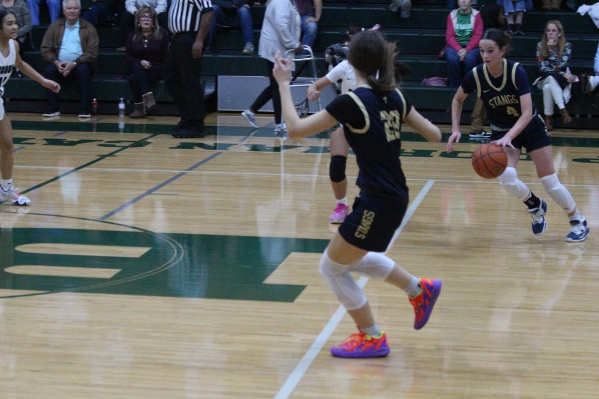 Junior Sadie Zbranek dribbles up the court around her defender.