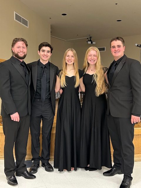 MCA choir students prepare to sing on stage.