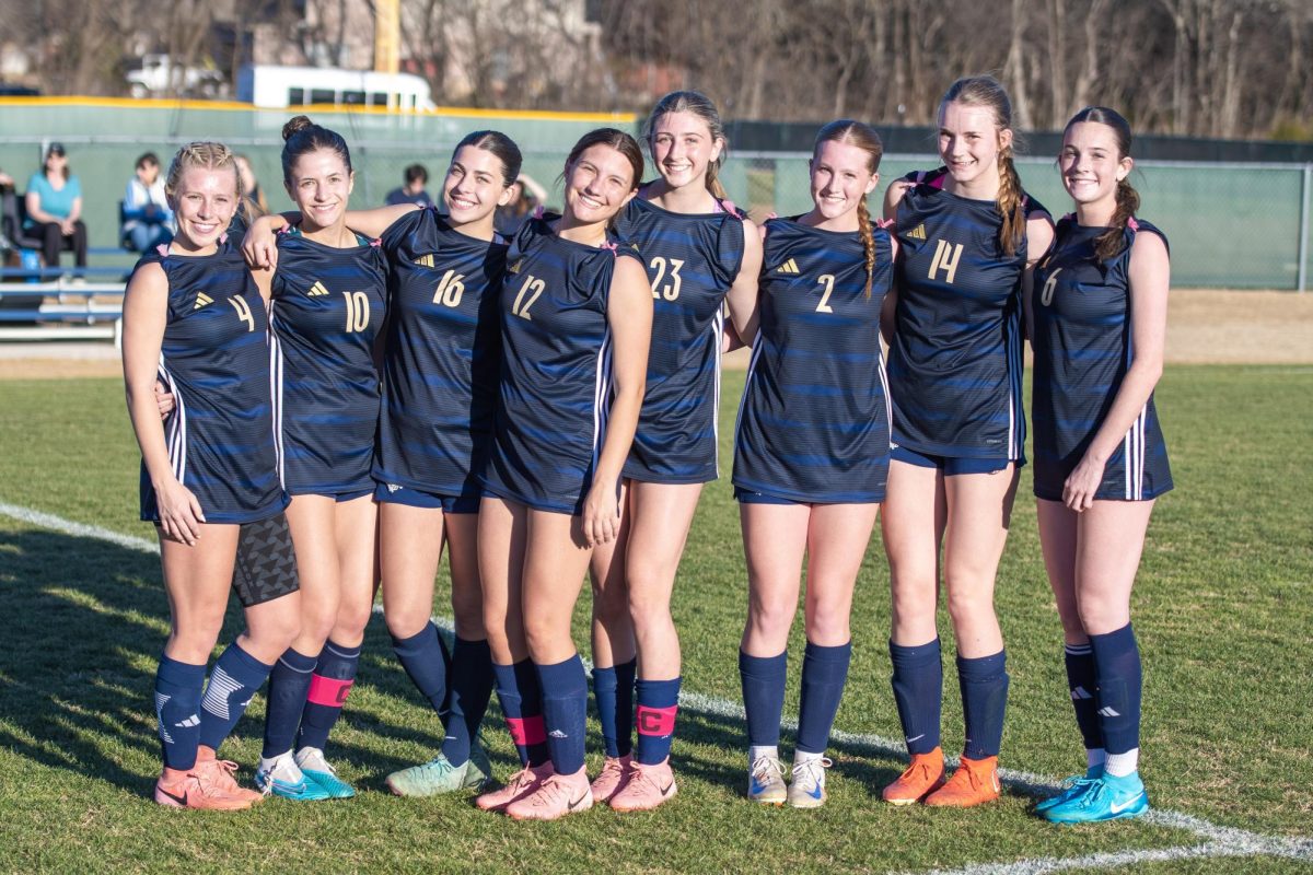 The varsity girl's soccer team smile after the win. 