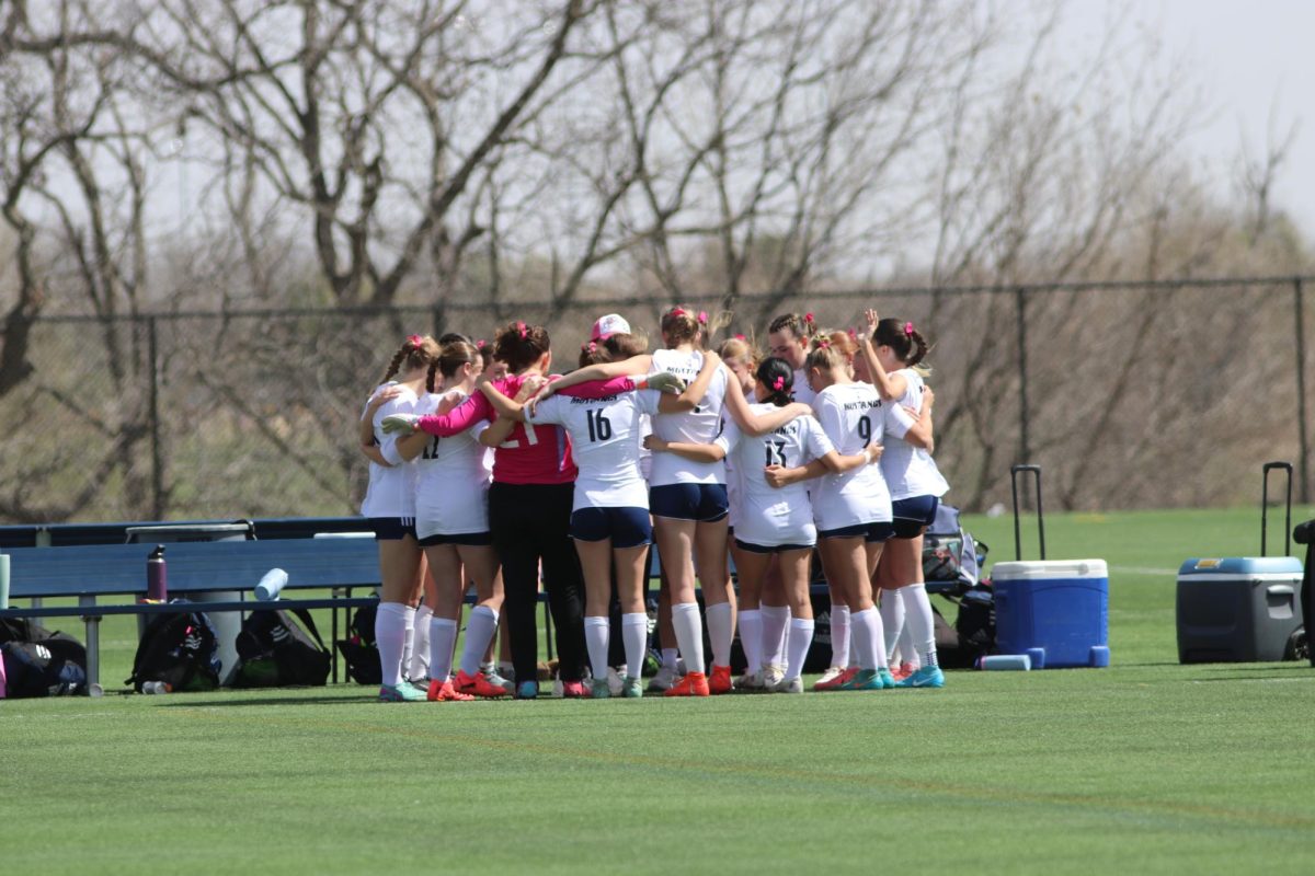 Girls huddle together to pray before game