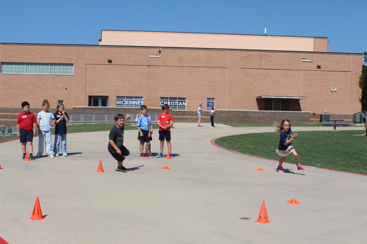 Group of students run around the cones.