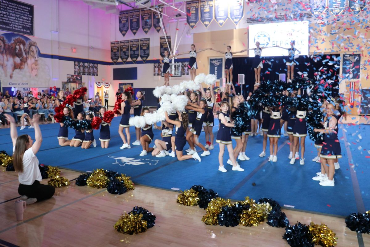 Cheerleaders end their routine with a band. 