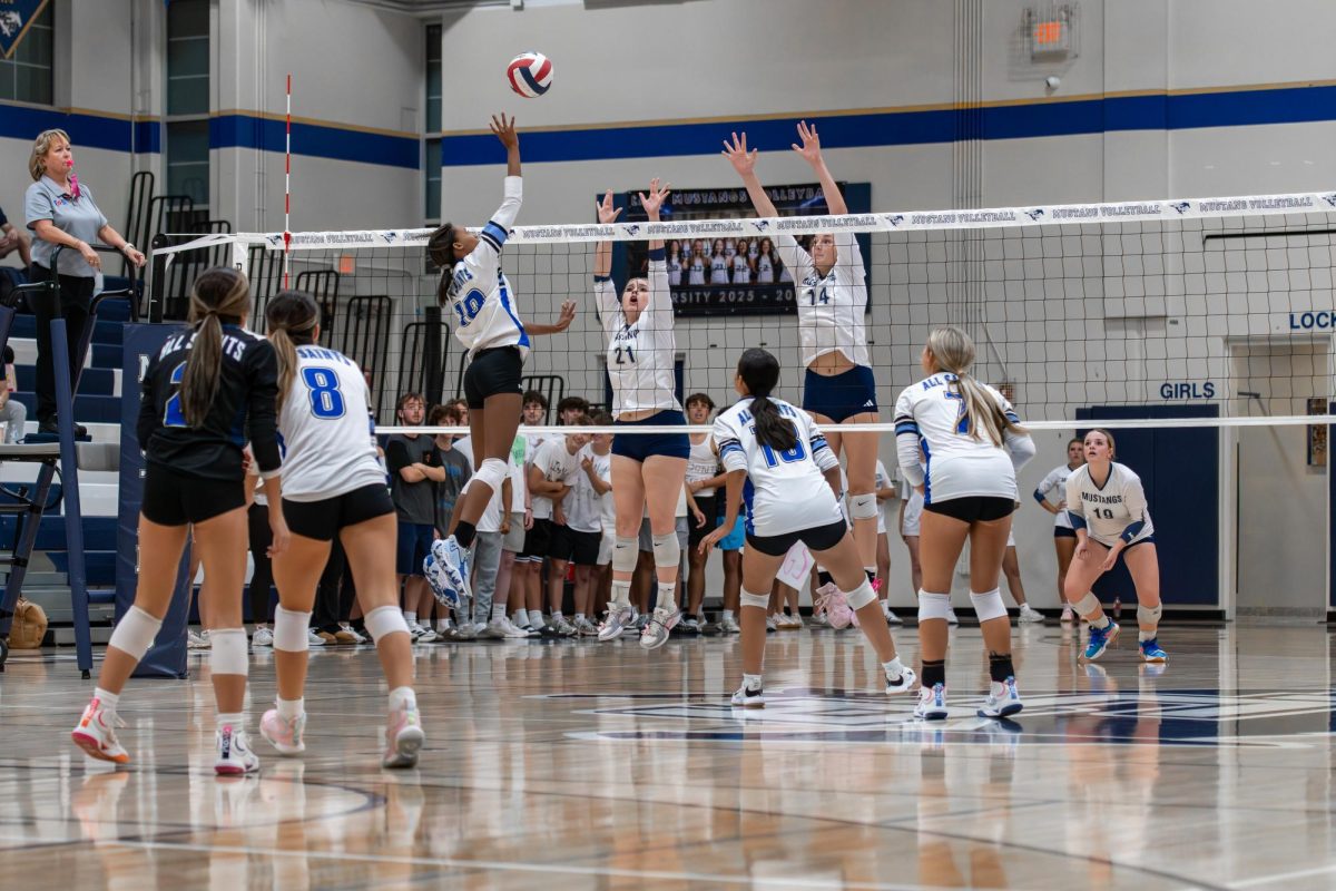 Senior Sadie Blake and sophomore Tatum Carroll work together to block the other team.