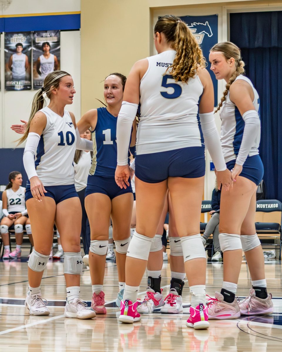 The Mustangs huddle together after a point.