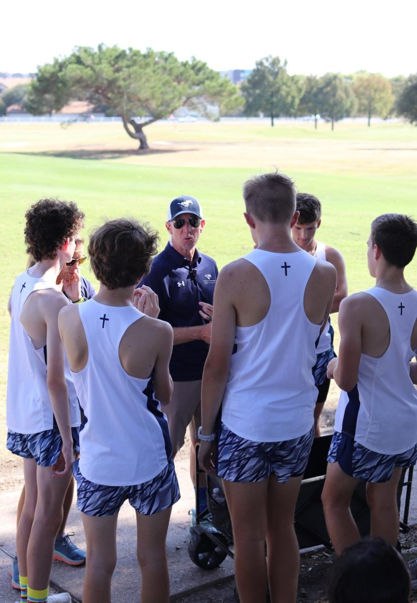 Coach Rhett McKeller talks to the boys' team before their race.