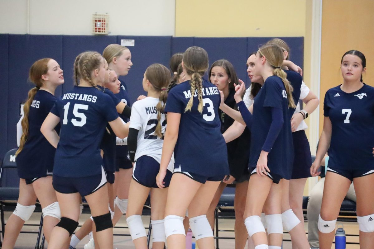 The coach talking to the players in the huddle 