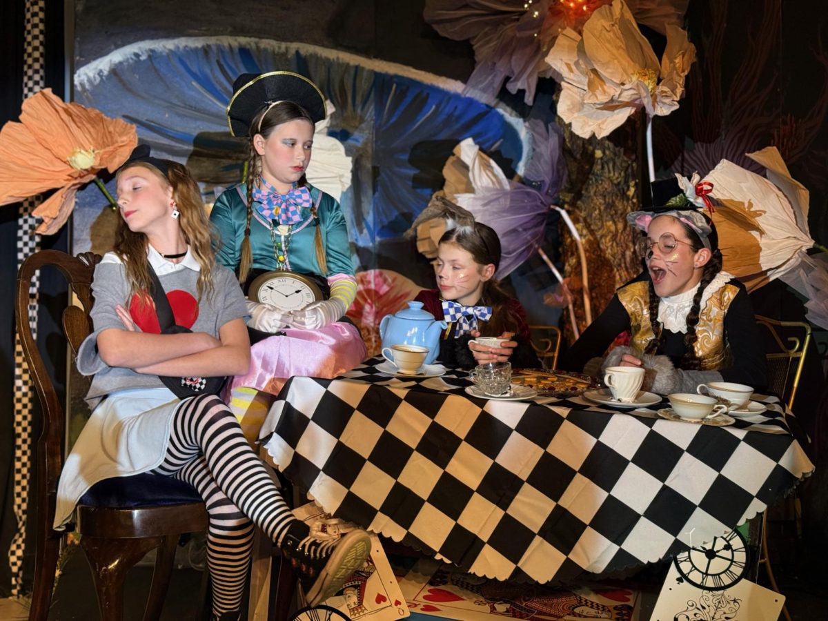 Sixth graders act together in the "Mad Tea Party" scene.