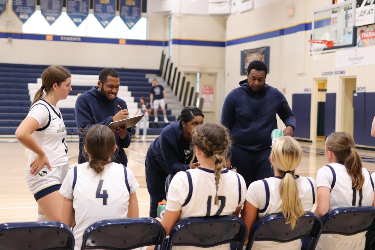 Girls sit on the bench to talk with the coach.