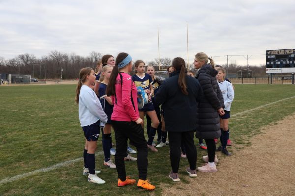 Team talks in huddle together.