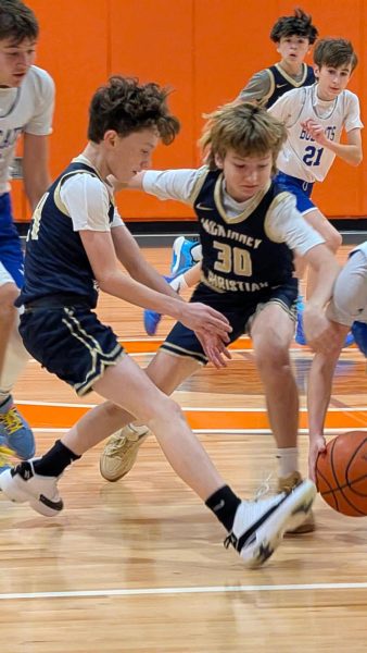 Boys basketball players rush towards the ball.